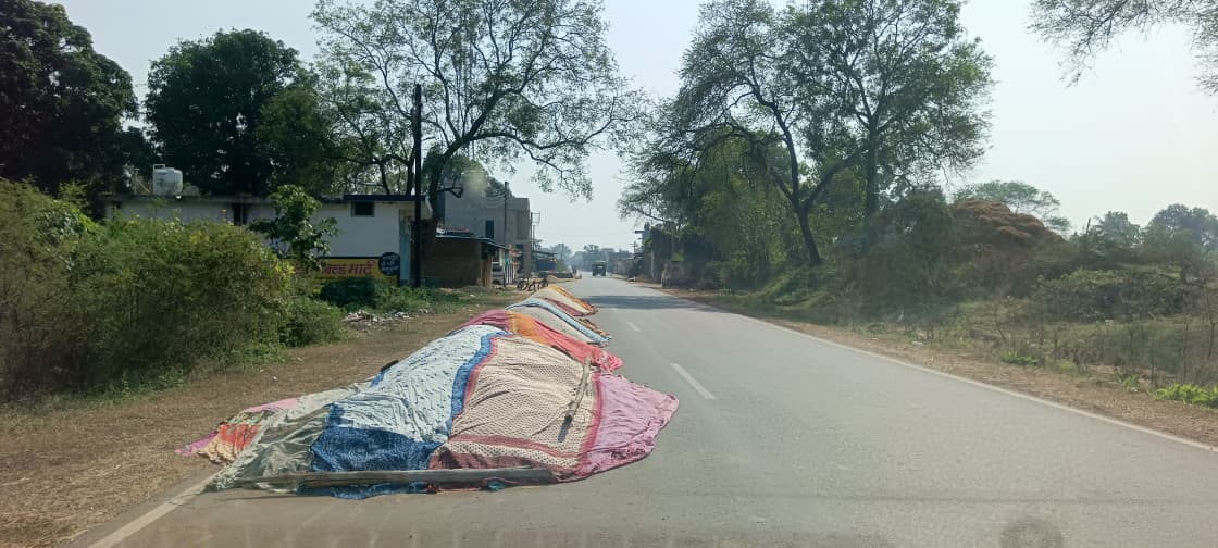 सड़क पर धान सुखा रहे किसान, बढ़ी दुर्घटना की आशंका